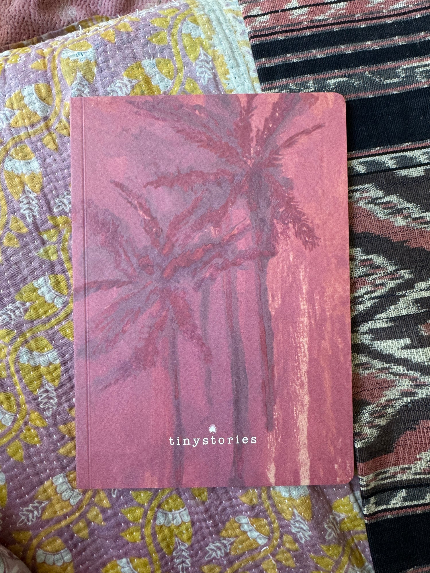 Notebook in size DIN A5 showing a drawing of two palmtrees in shaded of pink.