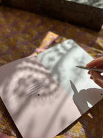 an open notebook and a person holding a pencil